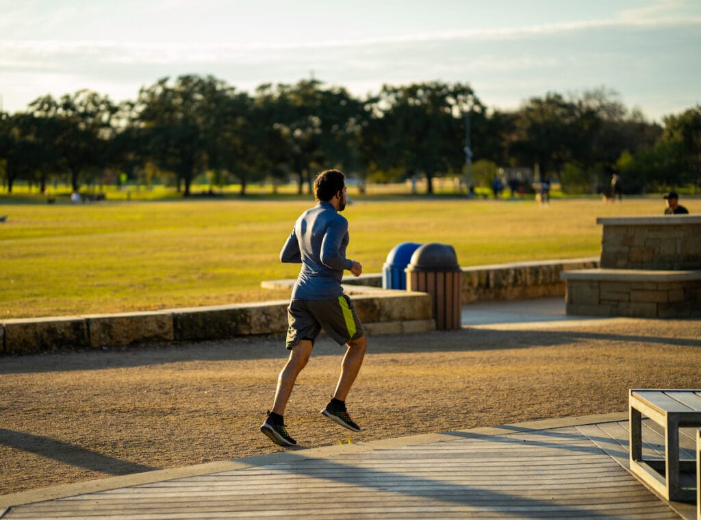 Man jogging in Austin park during high pollen season.