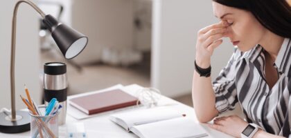 Woman experiencing workplace allergy symptoms at desk